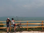 Riders pause to take in the vast turquoise horizons along the Gulf of Thailand’s scenic coastline.