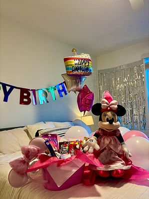 Hotel room decoration with balloons, plush toy, and personalized gift basket for special occasion in Orlando