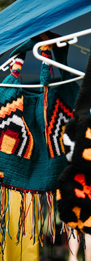 Handwoven colourful bilum bags with fringing hanging on display at an artisan stall