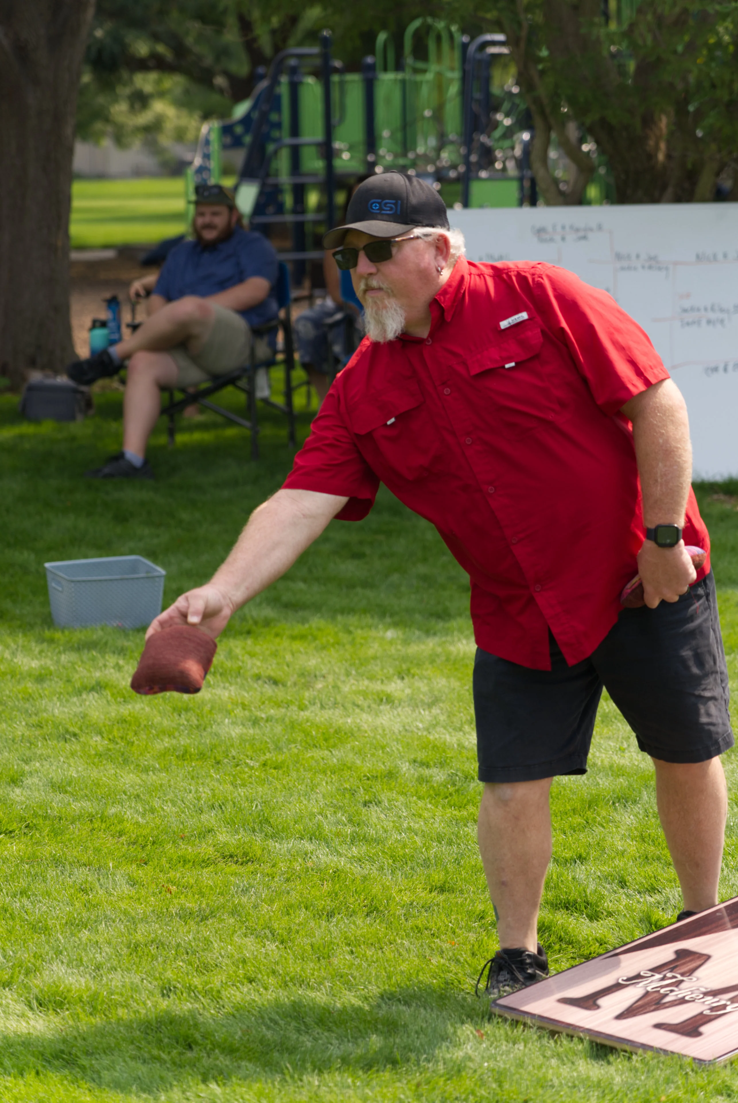 Joe Shanley throwing a bean bag in the final game of cornhole.