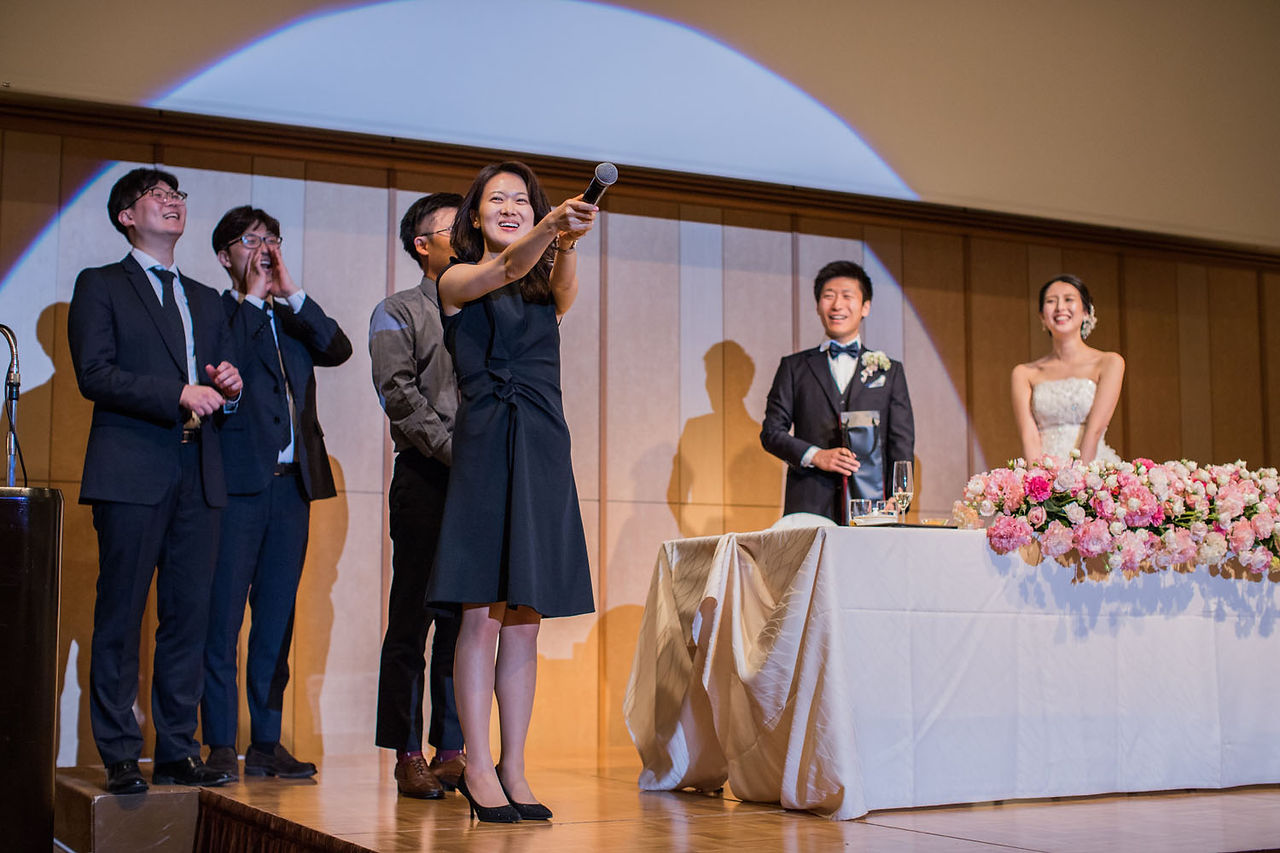 高輪貴賓館での結婚式で、二人のために用意した余興を披露する列席者の皆様と笑顔で見守る新郎新婦。