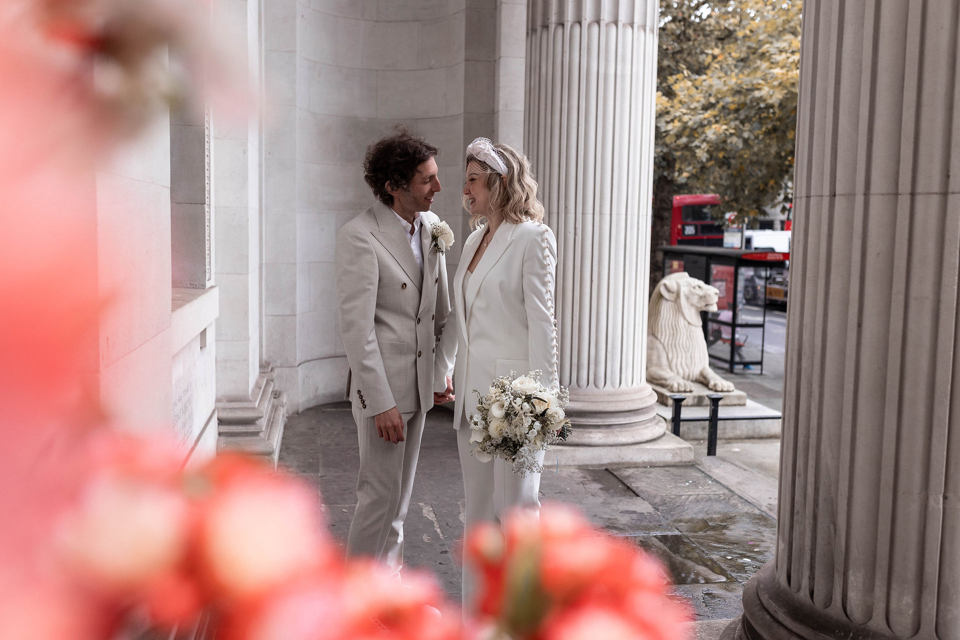 London buses in the background while the bride and groom soak in the newly married feelings outside the iconic Old Marylebone Town Hall