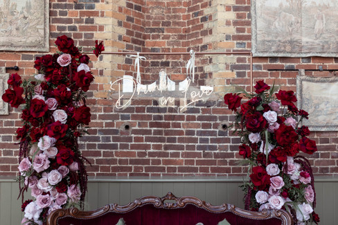 The drunk in love sign sits between the ceremony floral installation