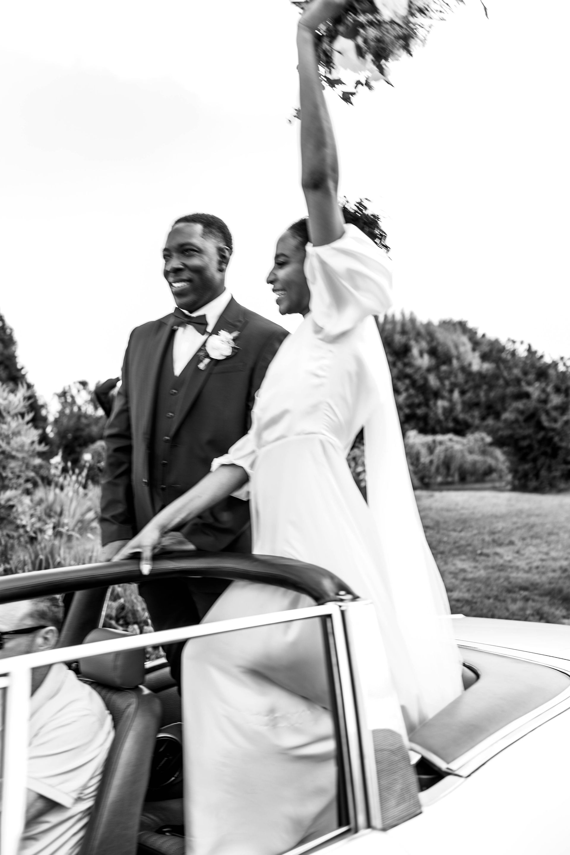 Black and white out of focus of the bride and groom sitting on top of a triumph stag