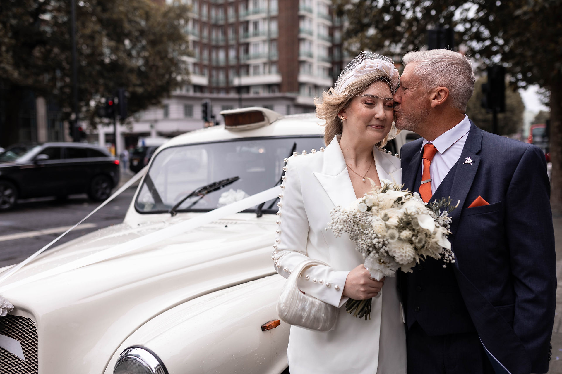 The Chicest bride with her Dad next to a white London Cab just before going into her London wedding at Old Marylebone town Hall