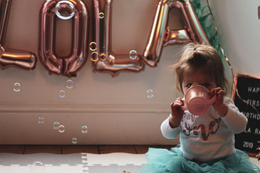 Baby sitting in front of Lola balloons