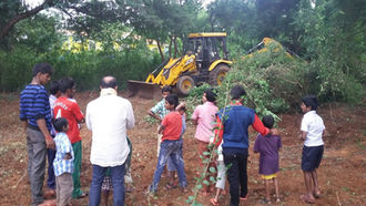 A tractor clears the undergrowth to make way for the boundary wall construction.
