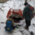 twp people stand outside a snowy tent