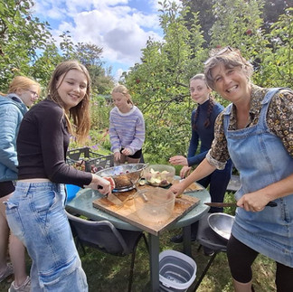 A teenage girl standing next to a table where she has been apple pressing