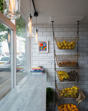 Retail shop interior with hanging wire baskets of fresh fruit