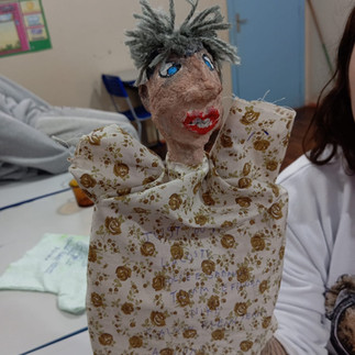 Fantoche de homem com cabelos cinza, vestindo uma roupa estampada.