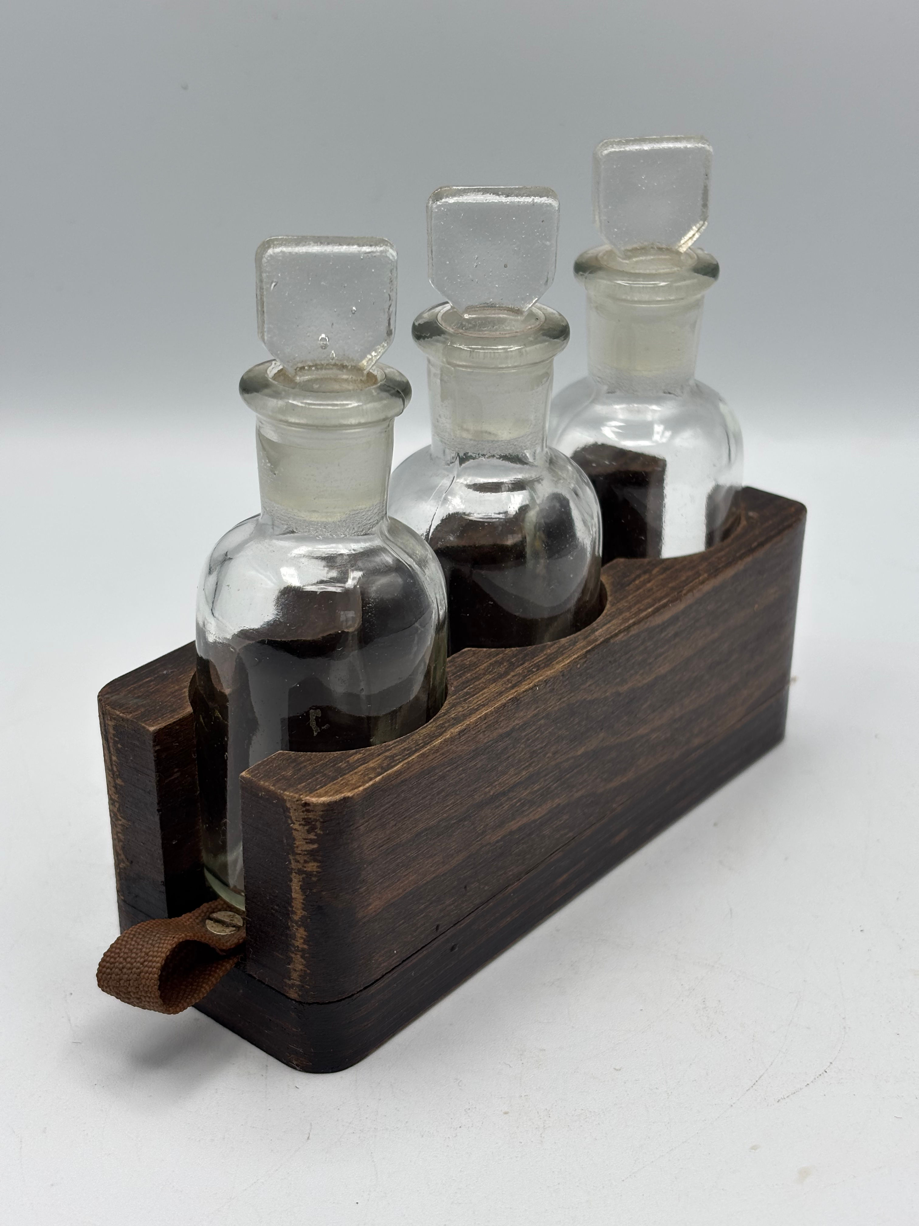 Set of Three Small Apothecary  Bottles with Stoppers in a Oak Holder