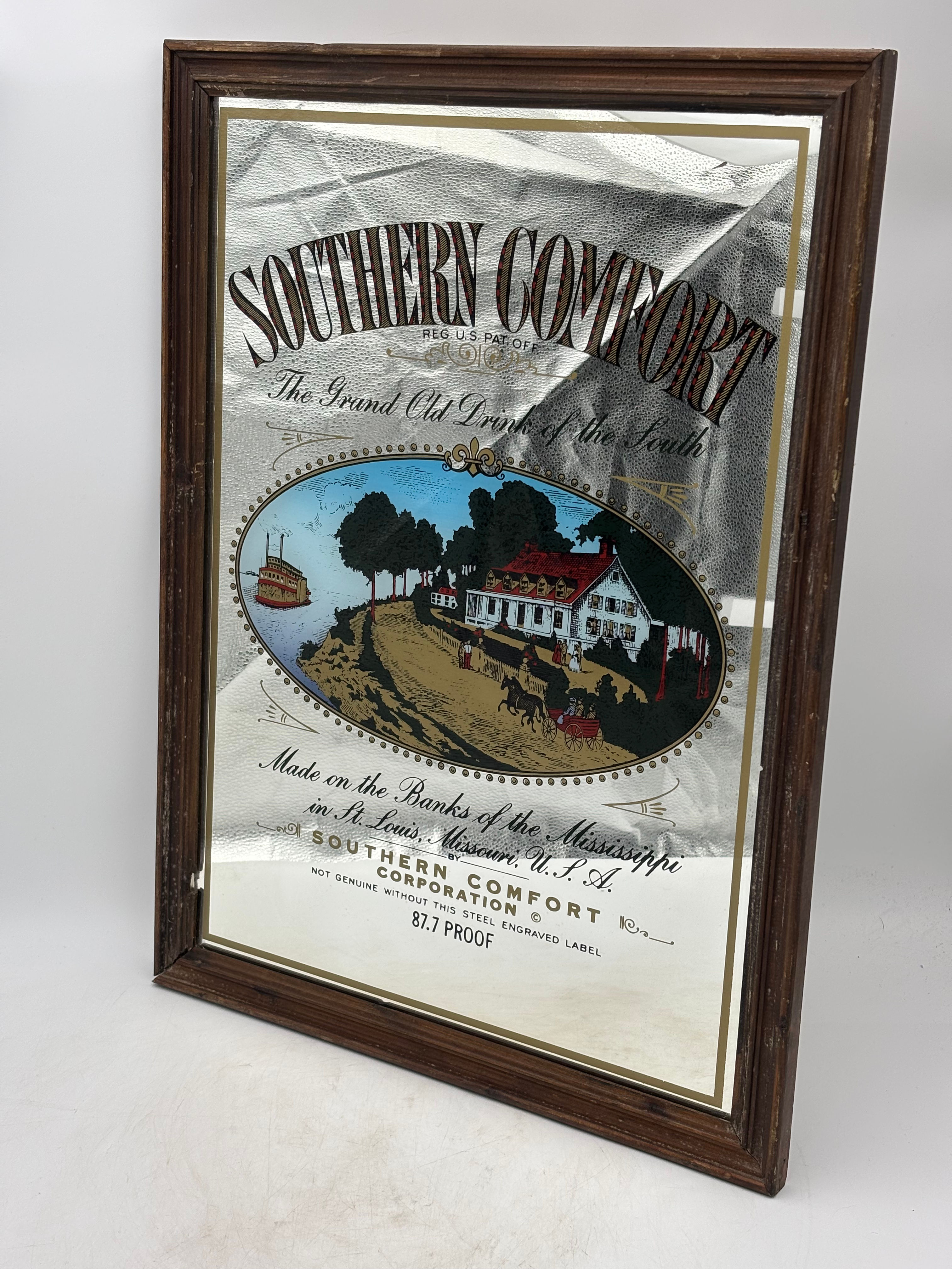 Vintage Southern Comfort advertising mirror in a wooden frame featuring a classi