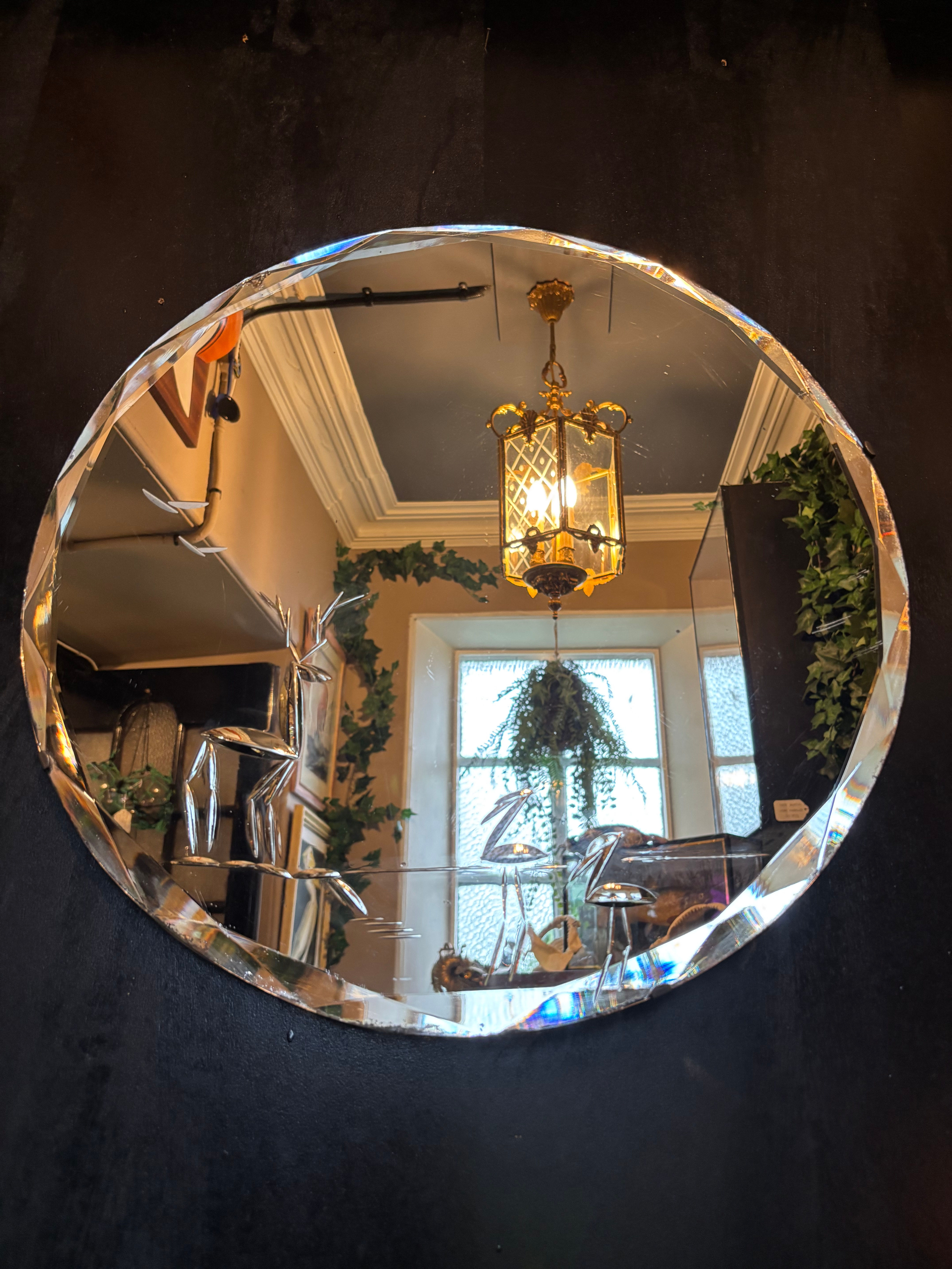 Vintage Art Deco round frameless wall mirror featuring wide, heavily bevelled ed
