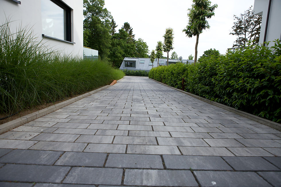 Hofeinfahrt gepflastert mit Betonpflaster und pflegeleichten Pflanzstreifen