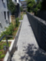 Treppenanlage und Wegeflächen mit Betonpflaster und Gabionen als Sichtschutz