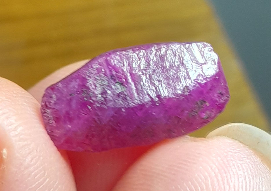 Cristal de saphir rose-pourpre terminé du Vietnam, translucide et brillant sous la lumière.