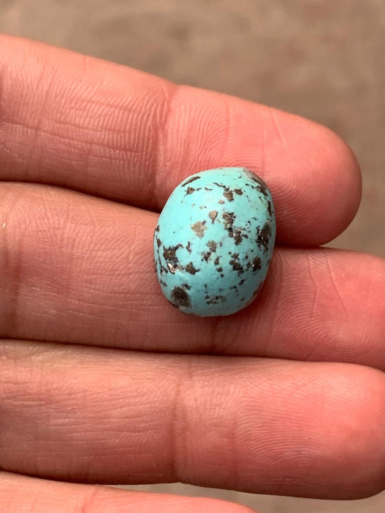 Turquoise bleu azur cabochon, inclusions matricielles naturelles sur fond neutre.
