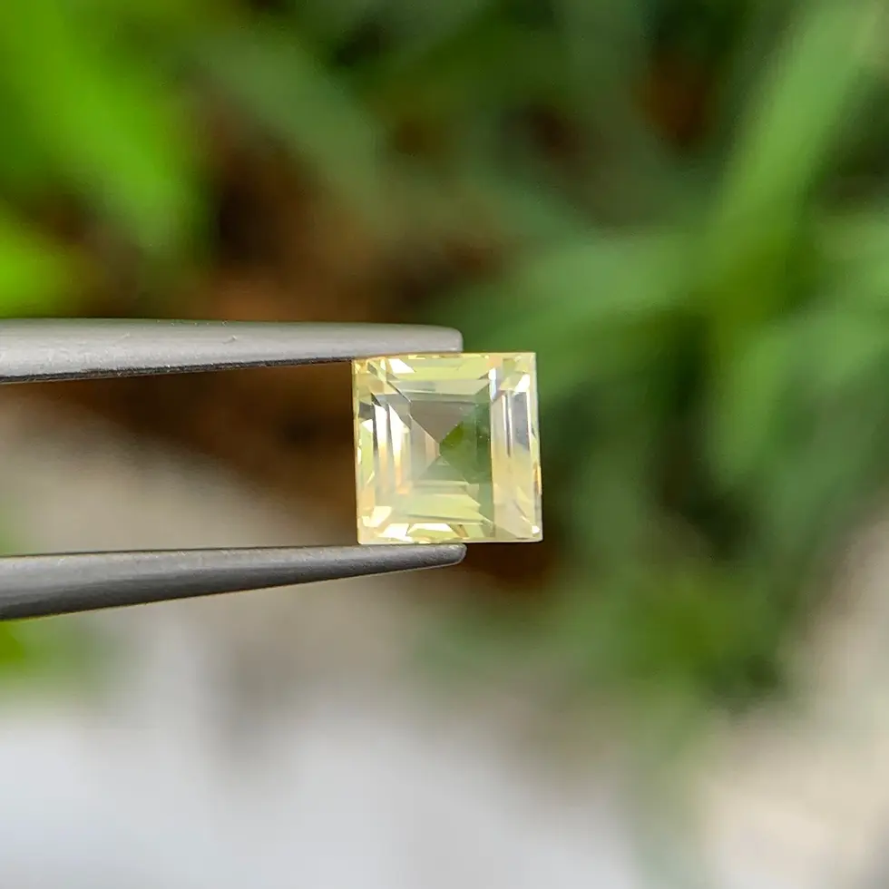 Saphir jaune carré, facettage symétrique et éclat cristallin sur fond flou.
