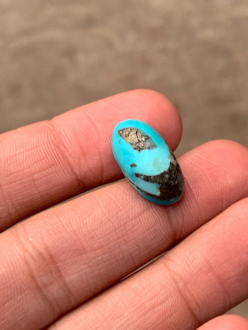 Turquoise bleu azur cabochon ovale allongé, surface lisse et couleur uniforme sur fond neutre.
