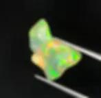 Opale éthiopienne naturelle de 6.45 carats avec reflets verts et oranges sur fond noir.