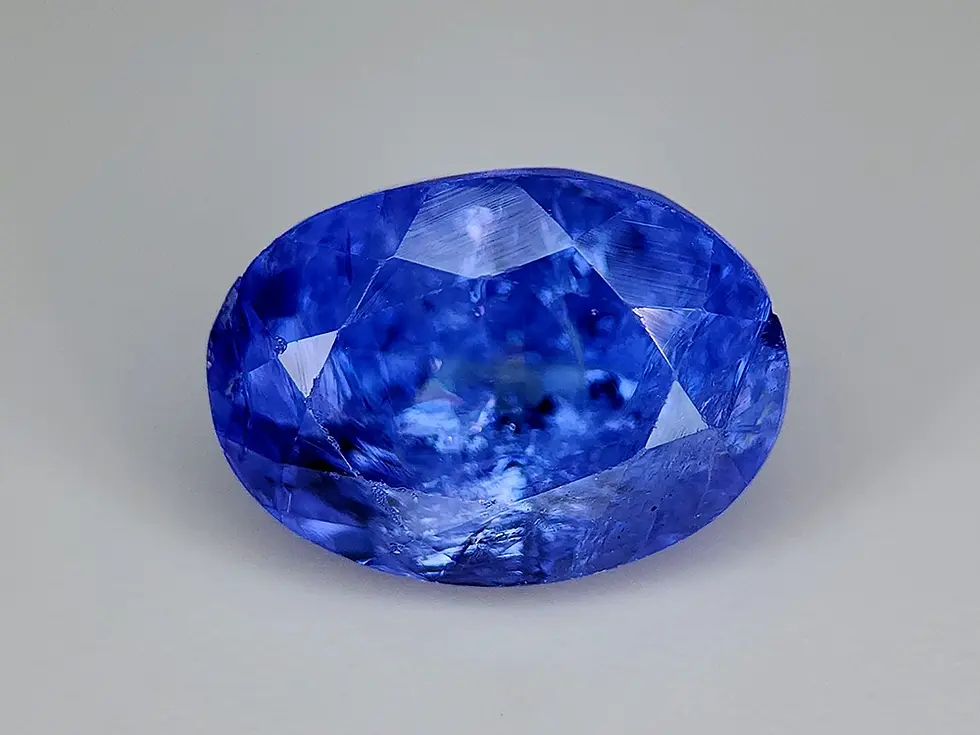 Tanzanite fancy 2.44 ct, couleur jaune-vert et brun, inclusions visibles, taille octogone brute.