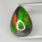 Opale fumée 5.35ct, jeu de couleurs vif vert et rouge, cabochon ovale sur fond neutre.