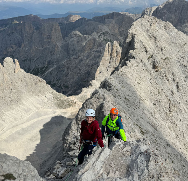 Climbers on exposed ridge traverse on Rosengarten Peak in the Dolomites