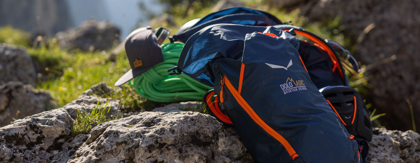 Climbing gear and backpack on rock ledge in the Dolomites during multi pitch climb