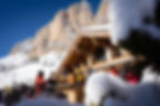 Skiers having a stop at a traditional mountain hut enjoying an aperitivo in the Dolomite mountains