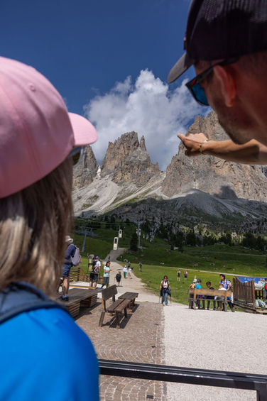 People enjoying panoramic Dolomites mountain views near via ferrata start with dramatic peaks in background