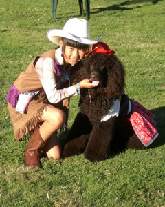This cowgirl (Madeline) and her four-legged friend (Riley) ham it up for the photographer at an outdoor show.