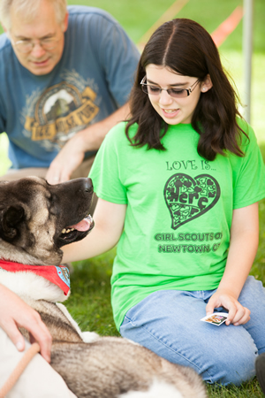At a Newtown, Conn., civic ceremony in late June honoring therapy-dog teams, Maggie Sheridan, a Reed Intermediate School sixth-grader, savors a few special moments with Spartacus, an Akita owned by Brad Cole, of Southbury, Conn. Maggie’s father, Jim Sheridan, watches. “Spartacus was the main driving force in my healing,” says Maggie. “Without him I would probably still be lost and confused.”