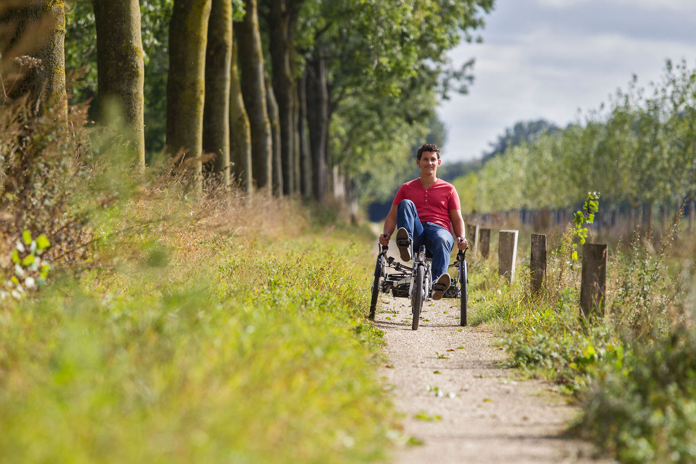 Un homme utilise le tricycle vanRaam Easy Sport sur un petit chemin