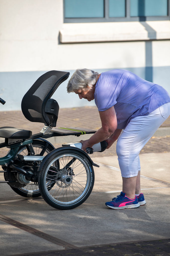 Une dame remplace la batterie de son tricycle électrique Easy Rider