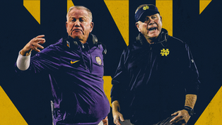 Two coaches with headsets gesture animatedly. One wears a purple shirt, the other navy with "ND" logo. Yellow and navy background.