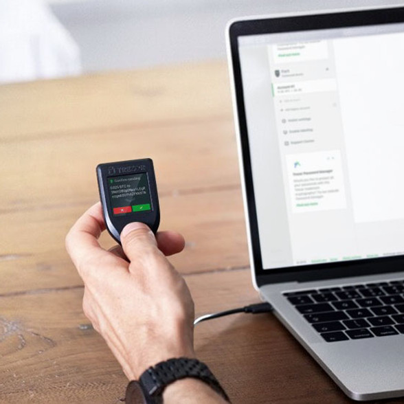 Image of a hand holding a Trezor Model-T hardware wallet