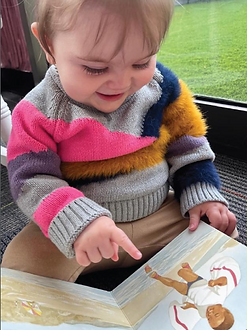 Infant sitting and reading at Cosmopolitan Kids daycare in Seattle