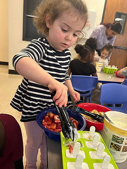 Cosmopolitan Kids preschool student making popsicles