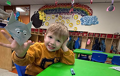 Cosmopolitan Kids preschooler showing off art