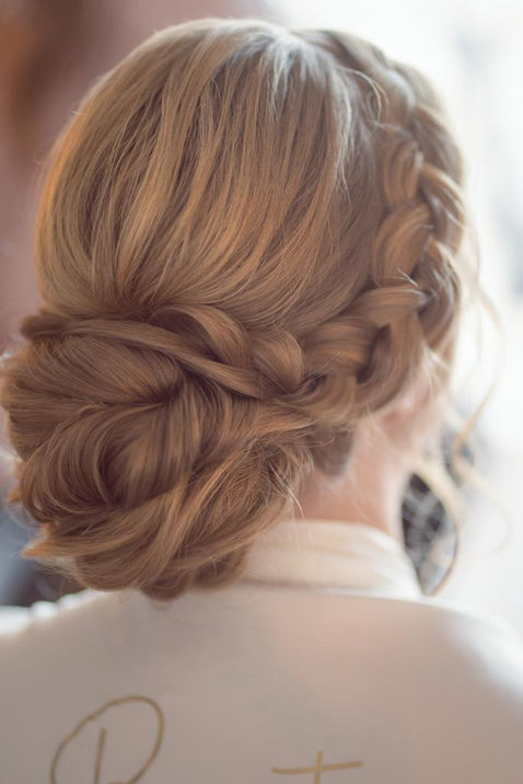 Eine Frau mit Hochsteckfrisur, geflochtenem Haar und Brötchen. Brautstylistin Tina.