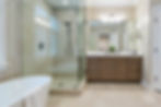 Spacious master bathroom featuring a modern freestanding bathtub, sleek cabinetry, and natural lighting for a luxurious retre
