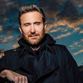 Portrait of a David Guetta  DJ wearing a dark coat, standing outdoors under dramatic clouds