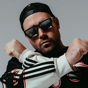 DJ Space 92 wearing sunglasses and a dark sports jacket with arms crossed