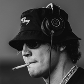 Black and White Image of a person wearing headphones and a cap while performing. 