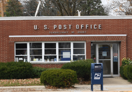 US Post Office brick building with classic blue mailbox out front in Schoolcraft, MI