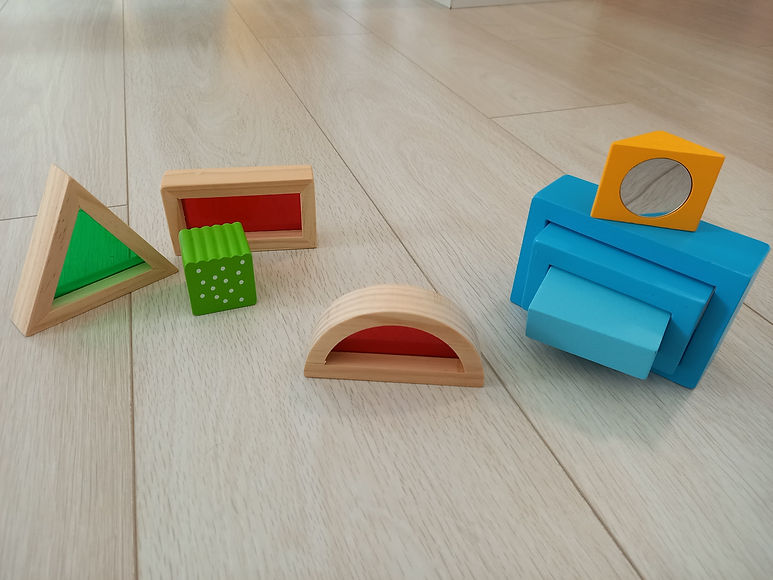 Bunte Holzbausteine in verschiedenen Formen auf hellem Boden