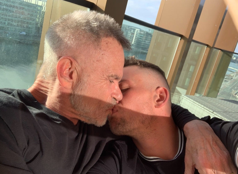 Gay couple Mike and Aaron share a kiss