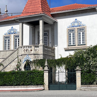 Elegant white building with red roof, windows, and gate in Portugal Travel