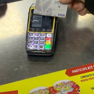 Person using a credit card for payment near a POS terminal with text Portugal Travel.